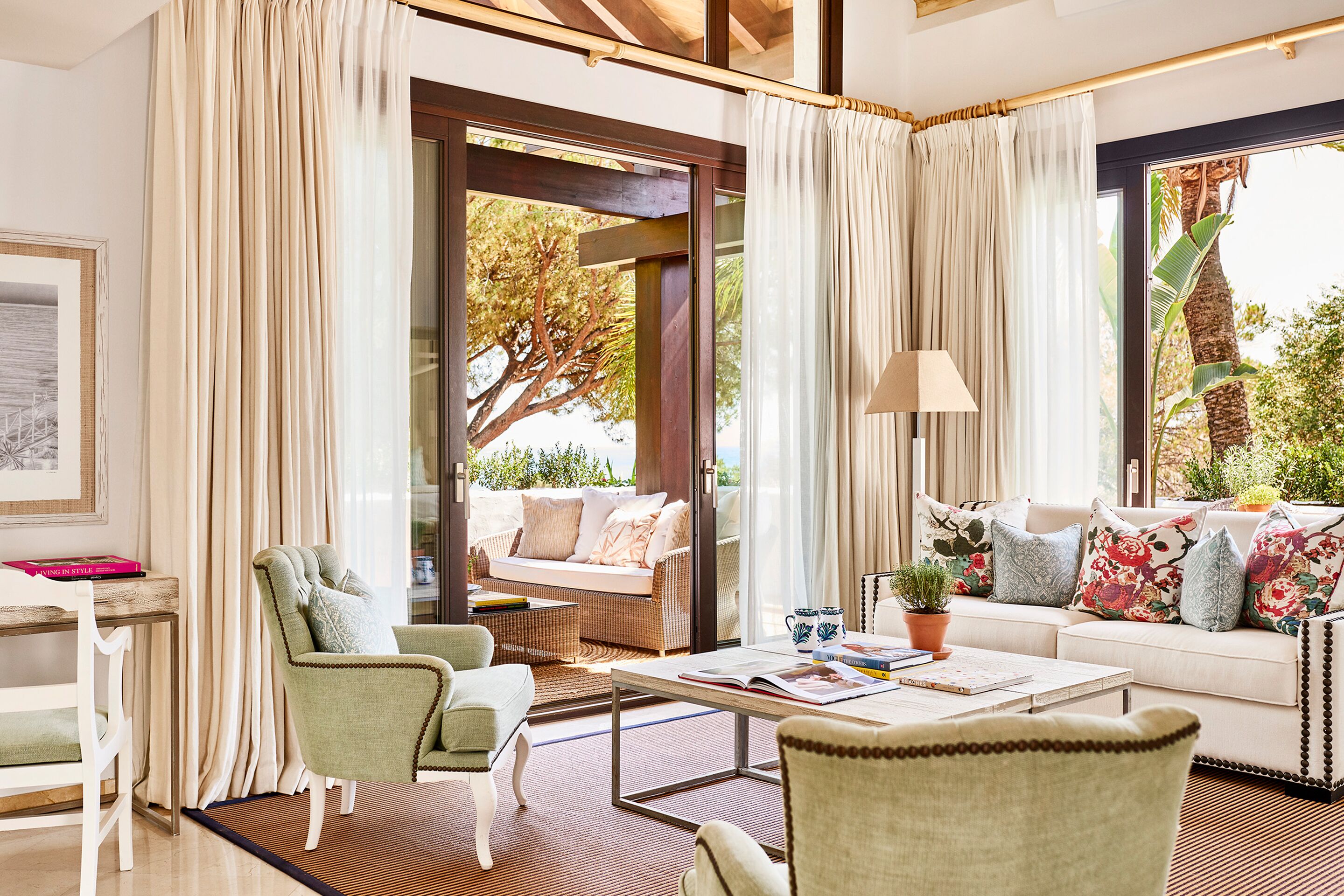 A modern living room with a sofa, chairs, a coffee table, and a view of the outdoors.