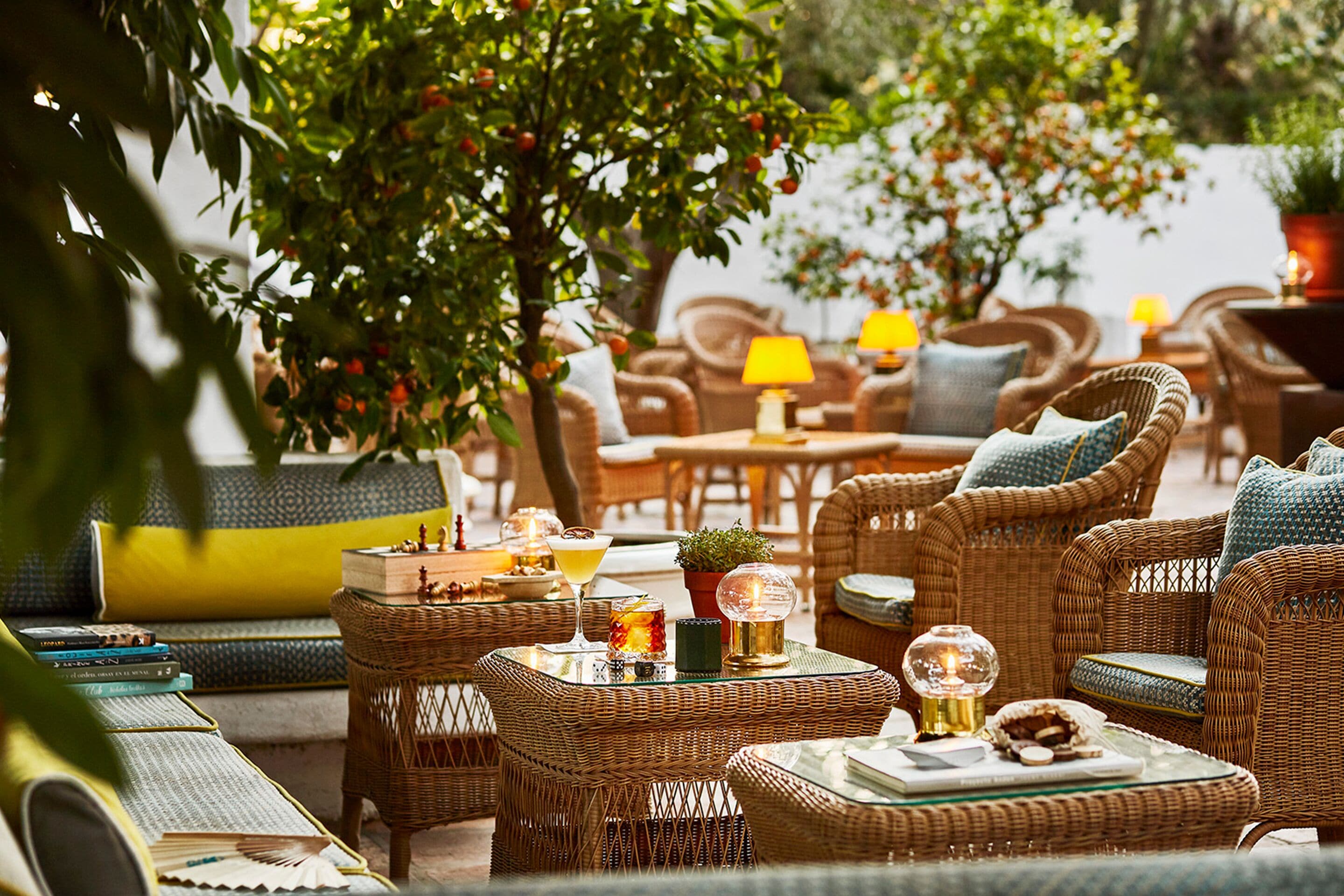 A wicker outdoor seating area with tables, chairs, and a potted plant.