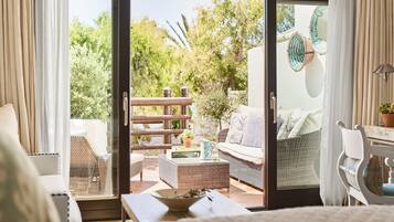 Una habitación acogedora con una puerta corrediza de vidrio que da a un espacio exterior con mobiliario.
