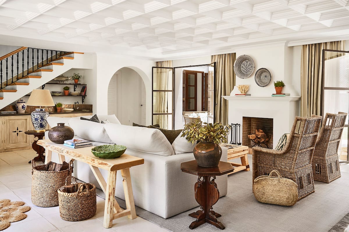 A spacious living room with a fireplace, comfortable seating, and a staircase.