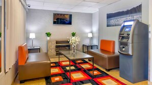 Una habitación de hotel moderna con chimenea, televisor de pantalla plana, refrigerador y alfombra estampada.