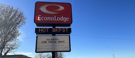 Señal de EconoLodge con servicios que incluyen desayuno gratuito, estacionamiento para vehículos grandes y desayuno caliente.