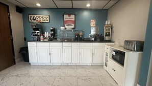 Una estación de café con una máquina de café, molinillos y un letrero que dice 'COFFEE'.