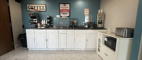 A coffee station with a coffee machine, grinders, and a sign that reads "COFFEE".