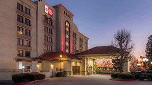 Un hotel con un llamativo letrero de 'Best Western', una entrada cubierta y un área de estacionamiento.