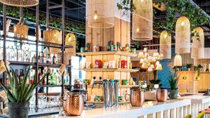 A bar area with a long counter, copper mugs, and green chairs. - Mercure Paris Orly Airport (Paray-Vieille-Poste)