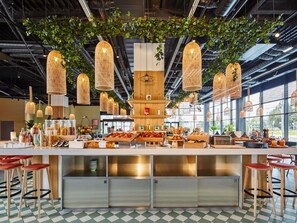 A modern cafe with a central counter, hanging wicker lamps, and a checkered floor. - Mercure Paris Orly Airport (Paray-Vieille-Poste)