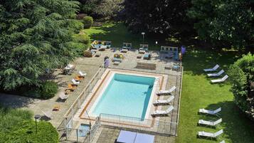 Una piscina al aire libre de temporada, sombrillas
