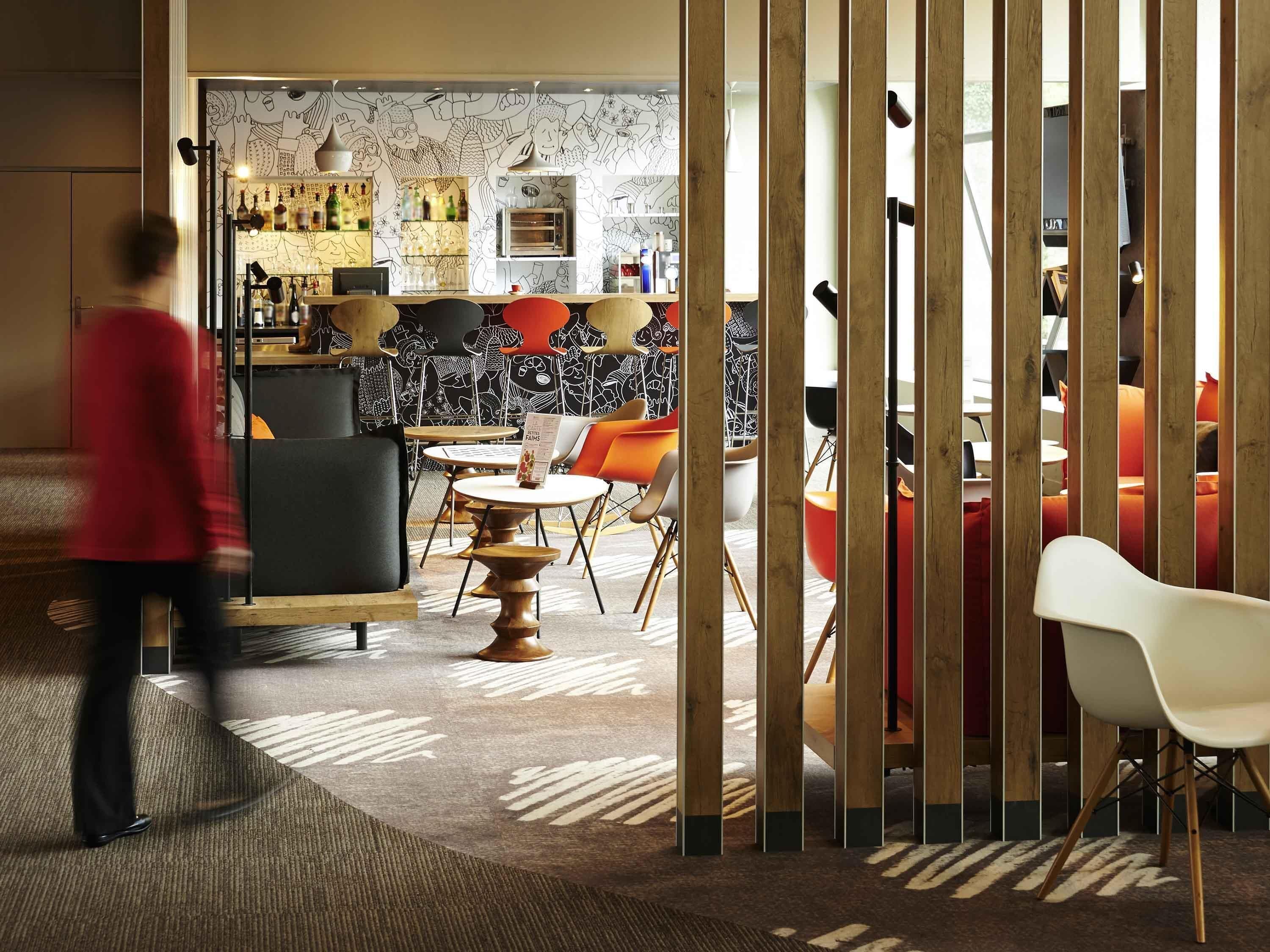A modern interior with a bar area, seating, and a patterned wall.