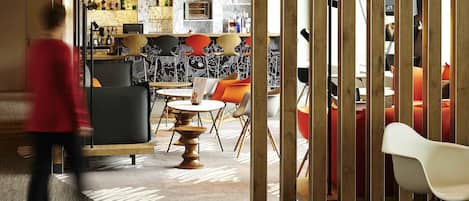 A modern interior with a bar area, seating, and a patterned wall.
