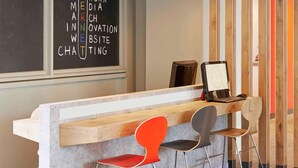 A modern workspace with a chalkboard displaying various business-related terms, a wooden desk with a laptop, and two chairs. - ibis Strasbourg Centre Historique (Strasbourg)
