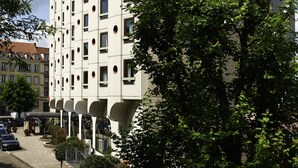 A modern hotel building with a distinctive architectural design, featuring a prominent 'ibis hotels' sign on the side. - ibis Strasbourg Centre Historique (Strasbourg)