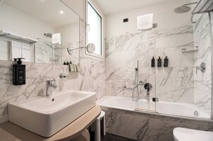 Un bagno moderno con un lavandino ampio, una vasca da bagno e uno spazio doccia.