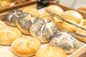 Een dienblad met verschillende soorten broodjes, waaronder papgaarzaad en gewone varianten.