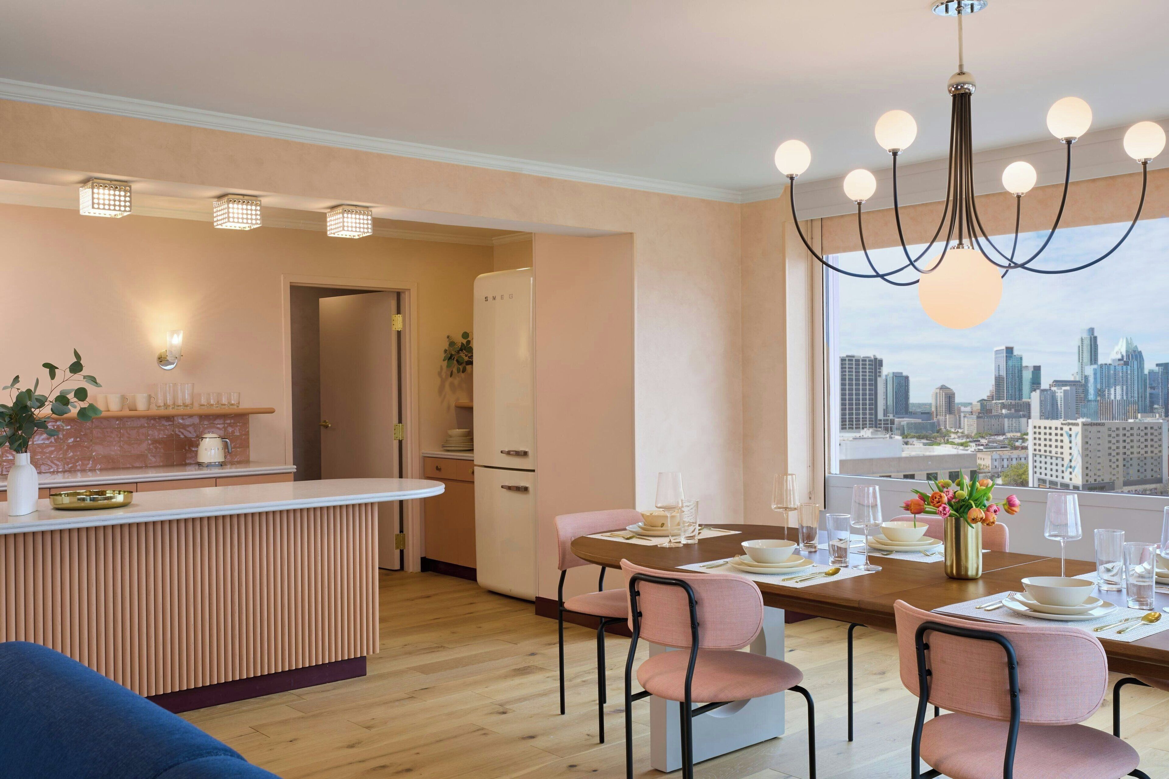 A modern kitchen with a dining area, a city view, and a bar area.