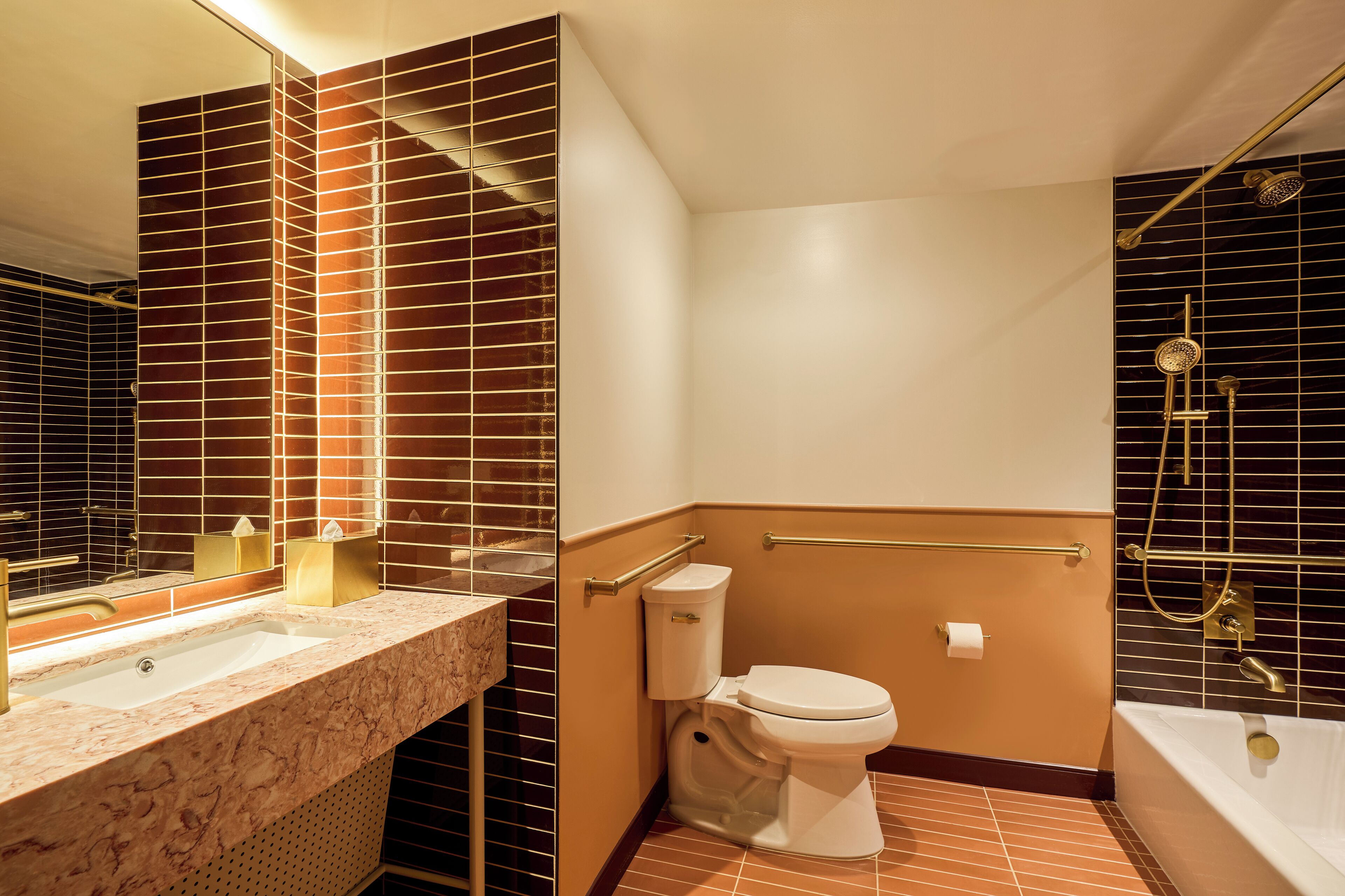 A bathroom with a marble sink, a toilet, a bathtub, and a shower with a handheld showerhead.