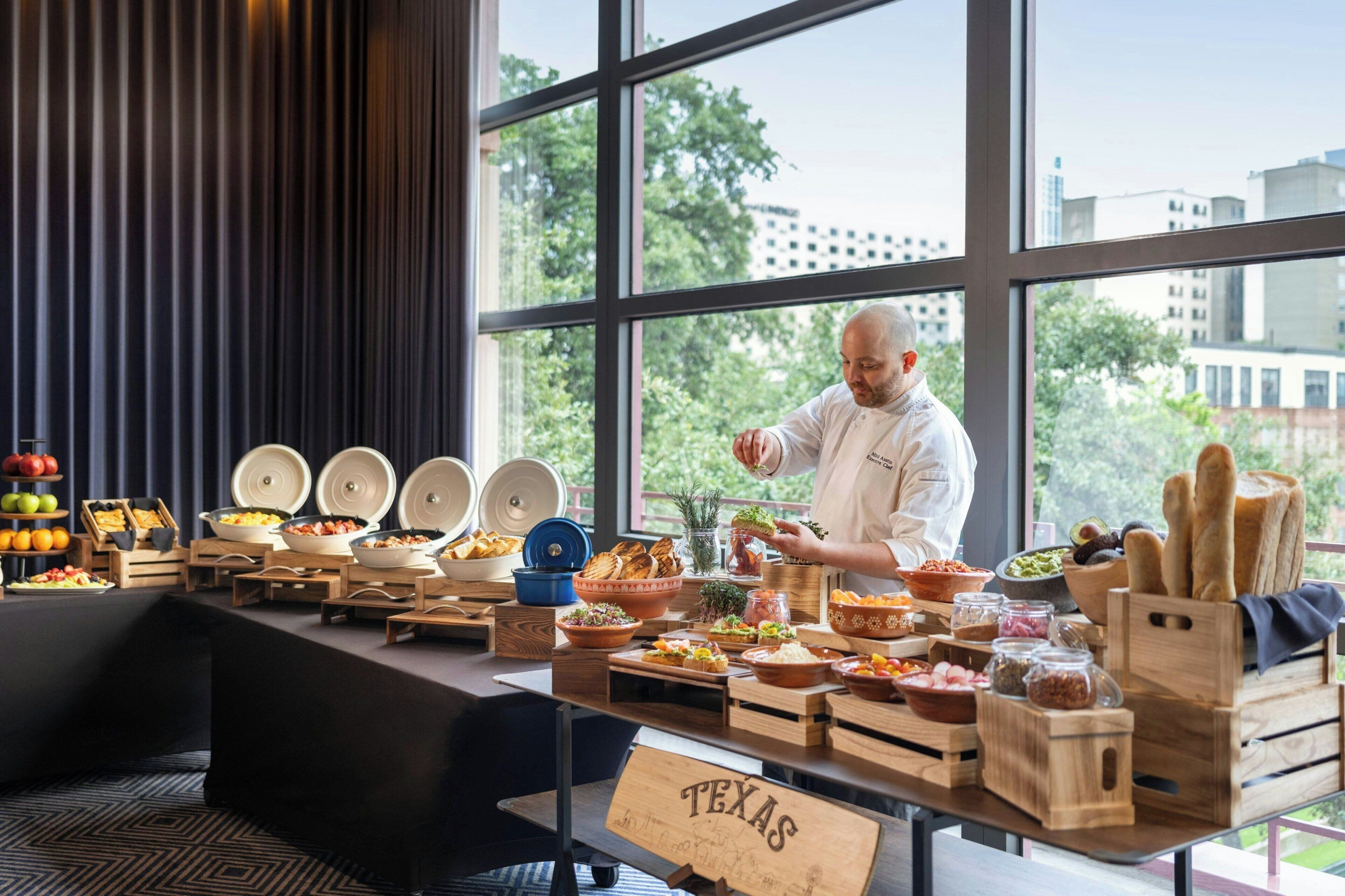 Ein Buffet mit verschiedenen Speisen und einem Koch, der zubereitet.