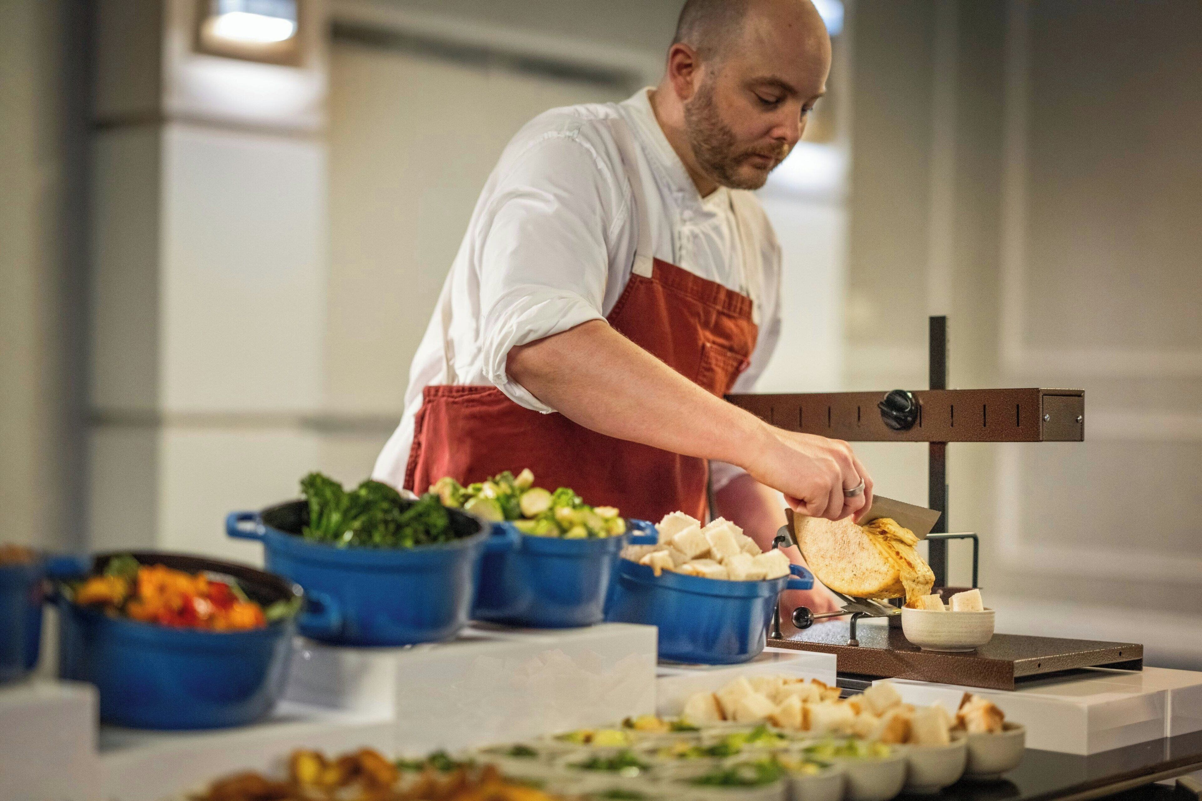 Een kok bereidt eten in een keuken, met diverse gerechten en kookattributen.