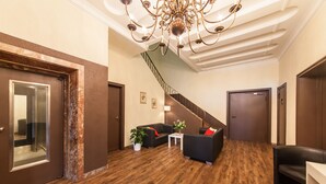 Un hall d’entrée moderne avec un plancher en bois, un escalier et un lustre.