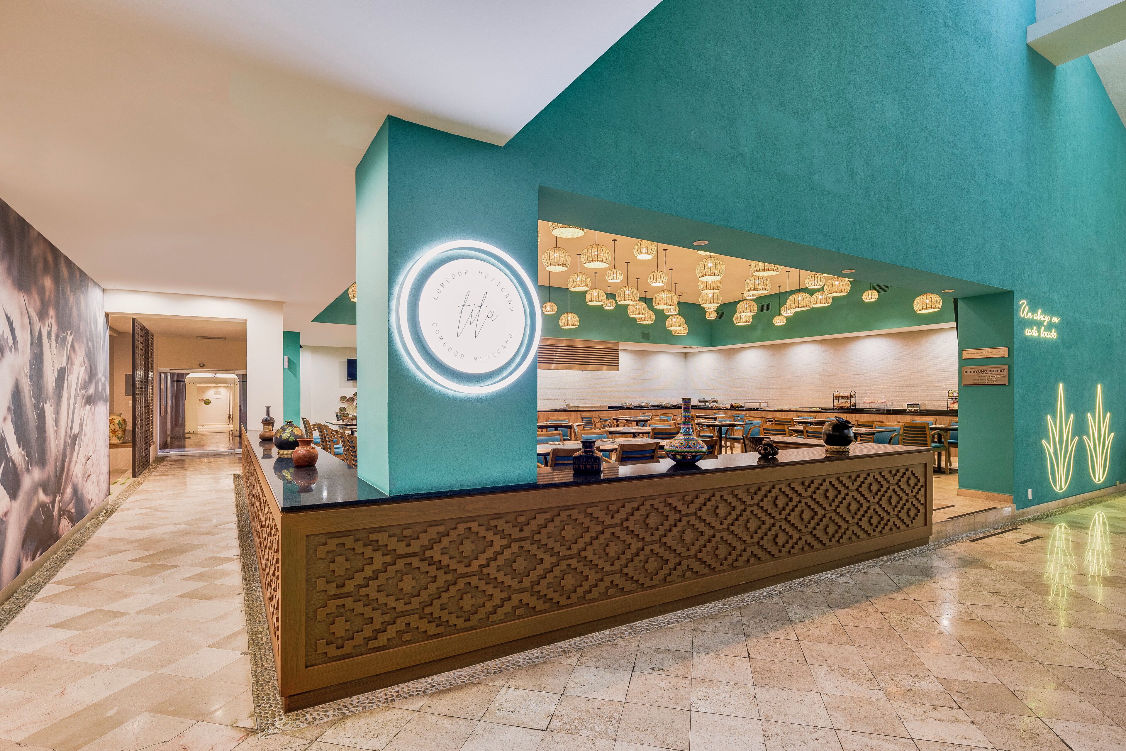 A reception area with a teal wall, a circular sign, and a patterned counter.