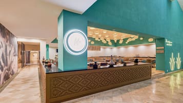 A reception area with a teal wall, a circular sign, and a patterned counter.