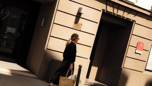 Una persona camina davant d'un edifici amb un rètol que indica un hotel.