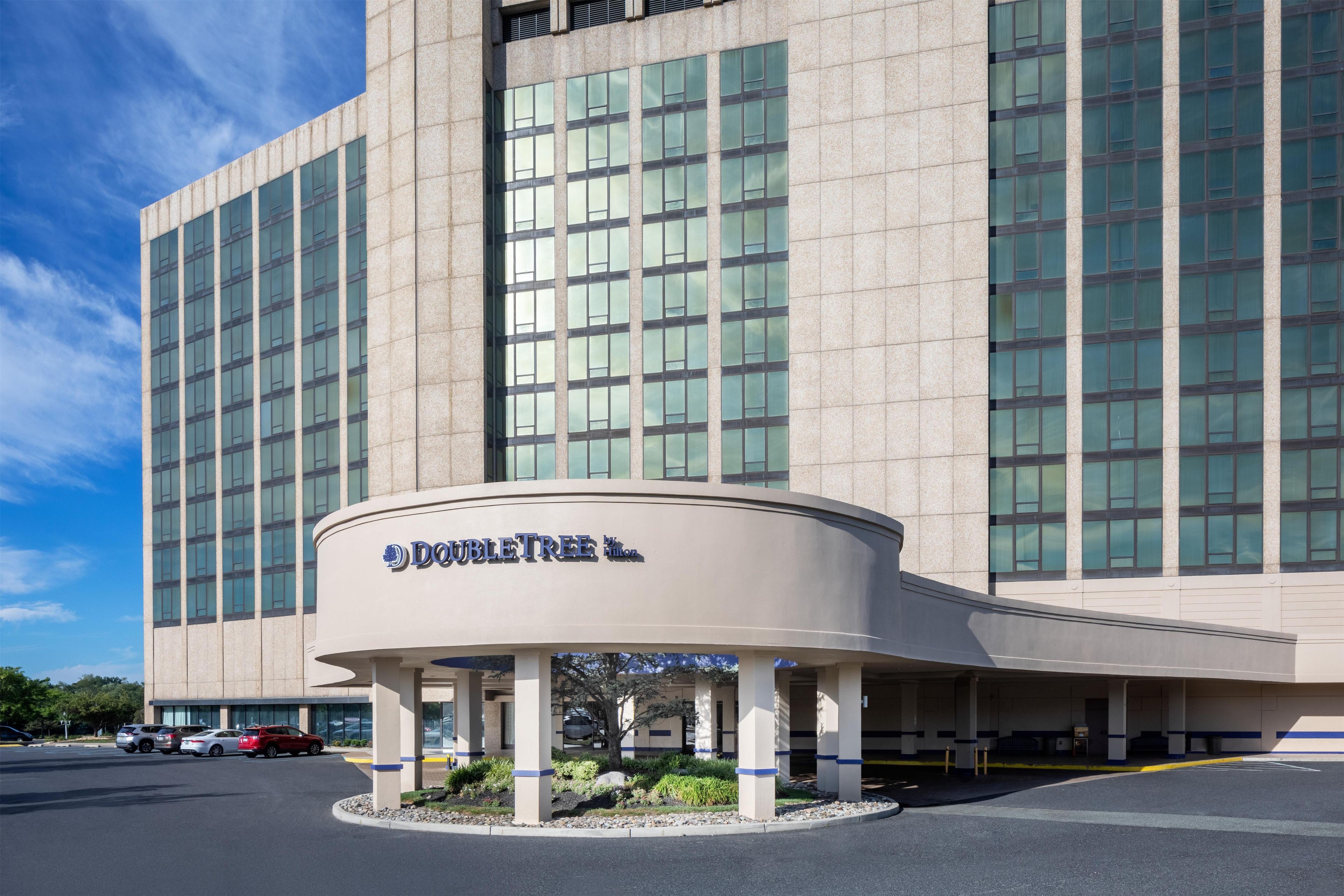 Un hotel con fachada moderna, amplias ventanas y una entrada destacada con un letrero.