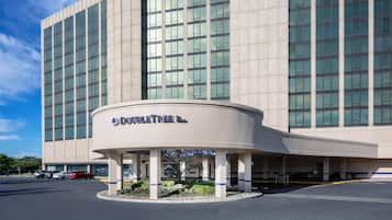 Un hotel con fachada moderna, amplias ventanas y una entrada destacada con un letrero.