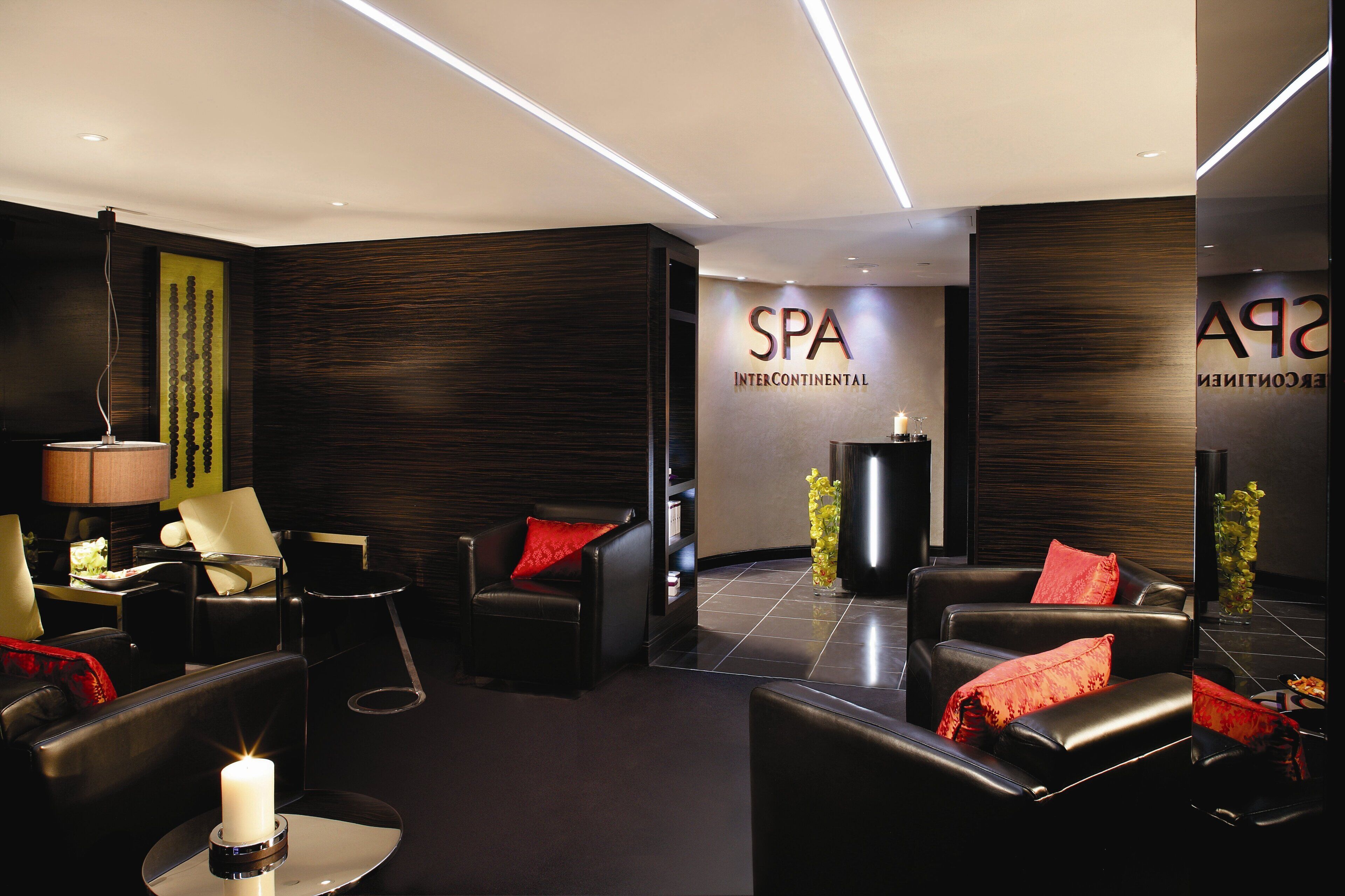 Interior moderno de spa con asientos de cuero, una recepción y un letrero en la pared.