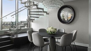 A modern dining area with a chandelier, a round mirror, and a staircase. - InterContinental London Park Lane by IHG (London)