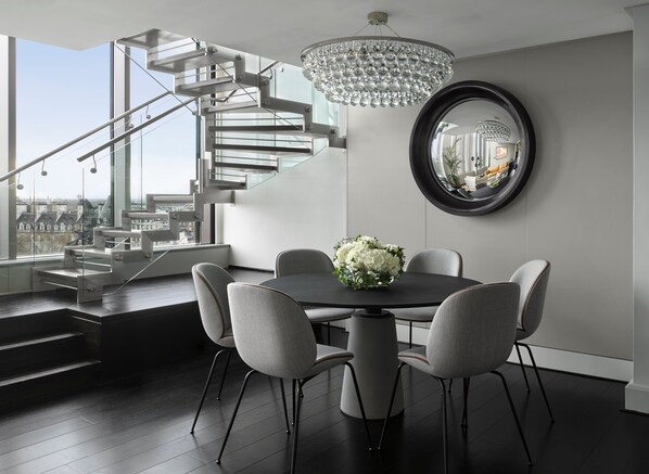 A modern dining area with a chandelier, a round mirror, and a staircase. - InterContinental London Park Lane by IHG (London)