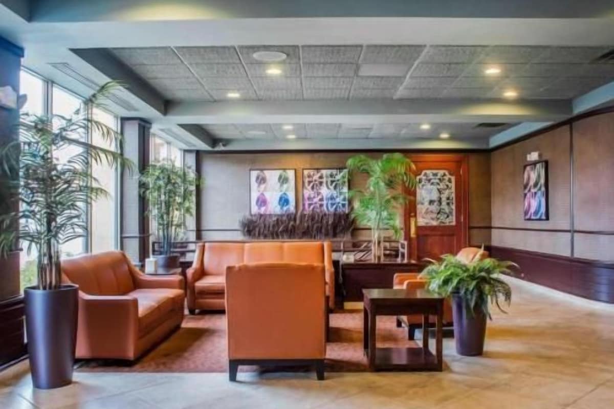 A lobby with seating, large windows, and artwork on the walls.