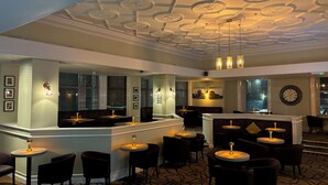 A bar area with a patterned ceiling, seating, and a clock on the wall. - Carlisle Station Hotel, Sure Hotel Collection by BW (Carlisle)