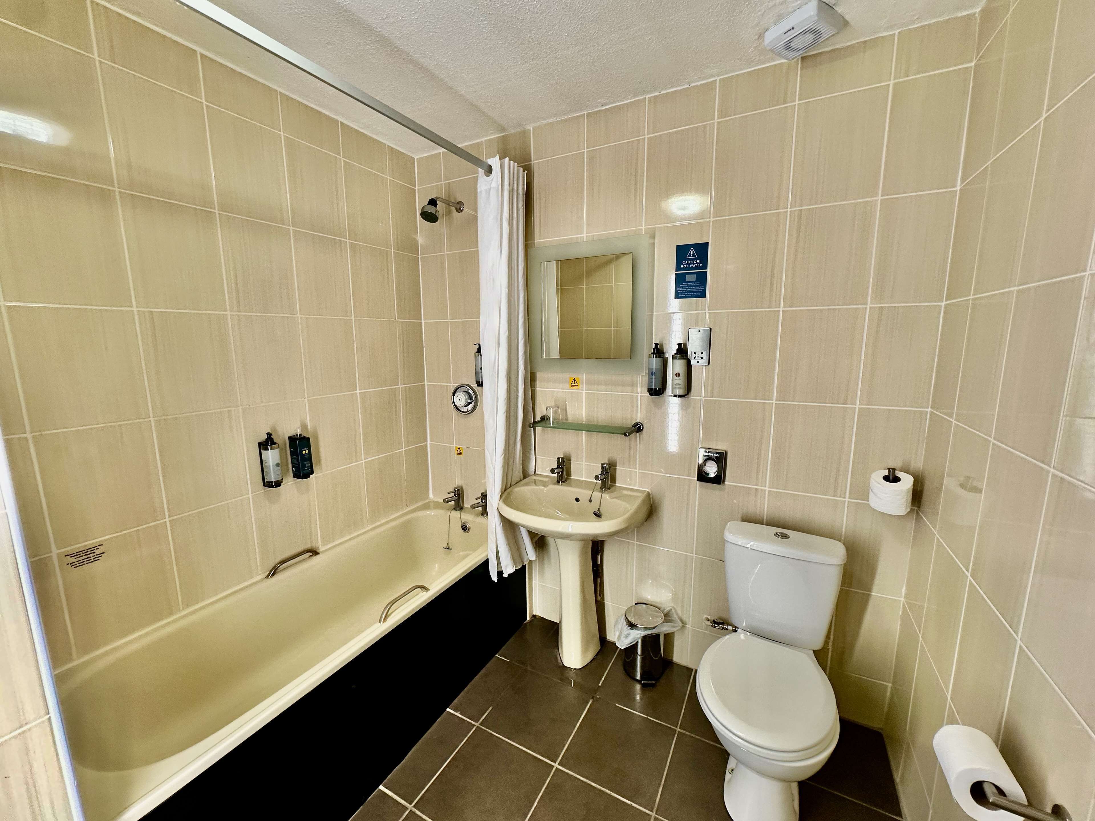 Un baño con bañera, lavamanos e inodoro.