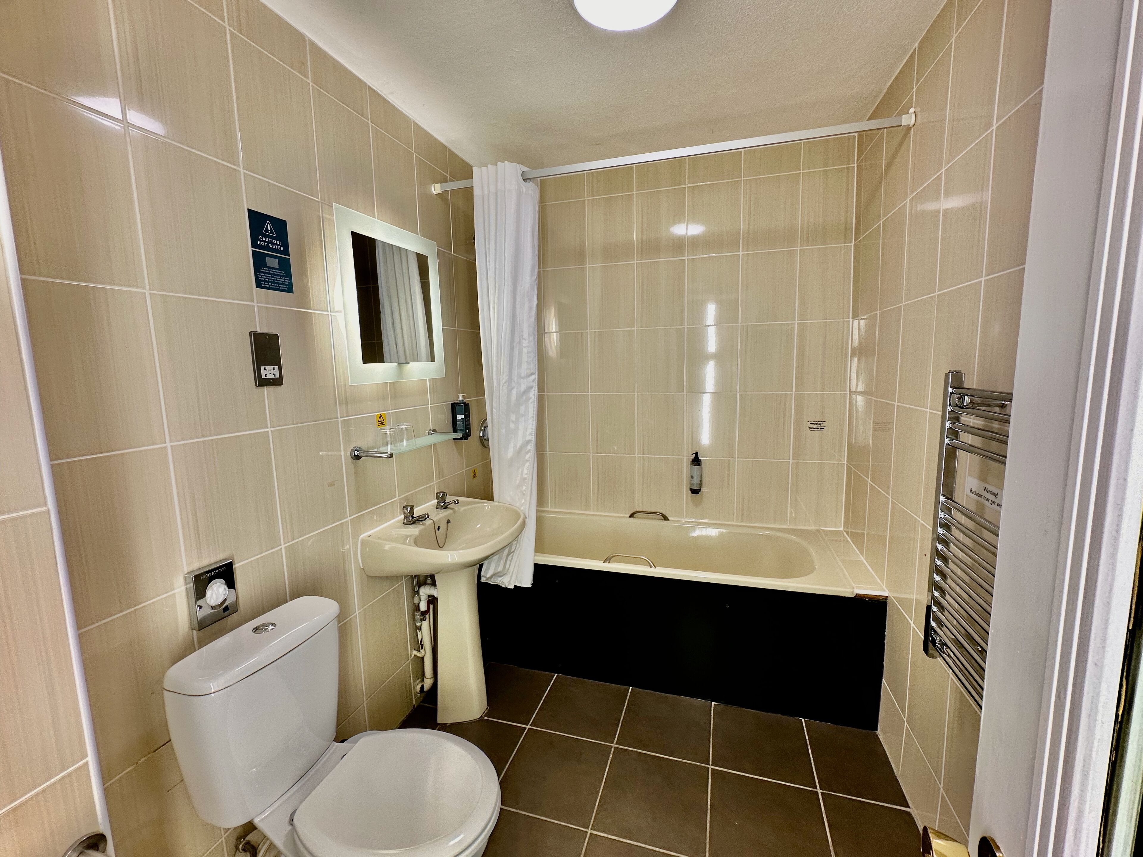 A bathroom with a toilet, sink, and bathtub.