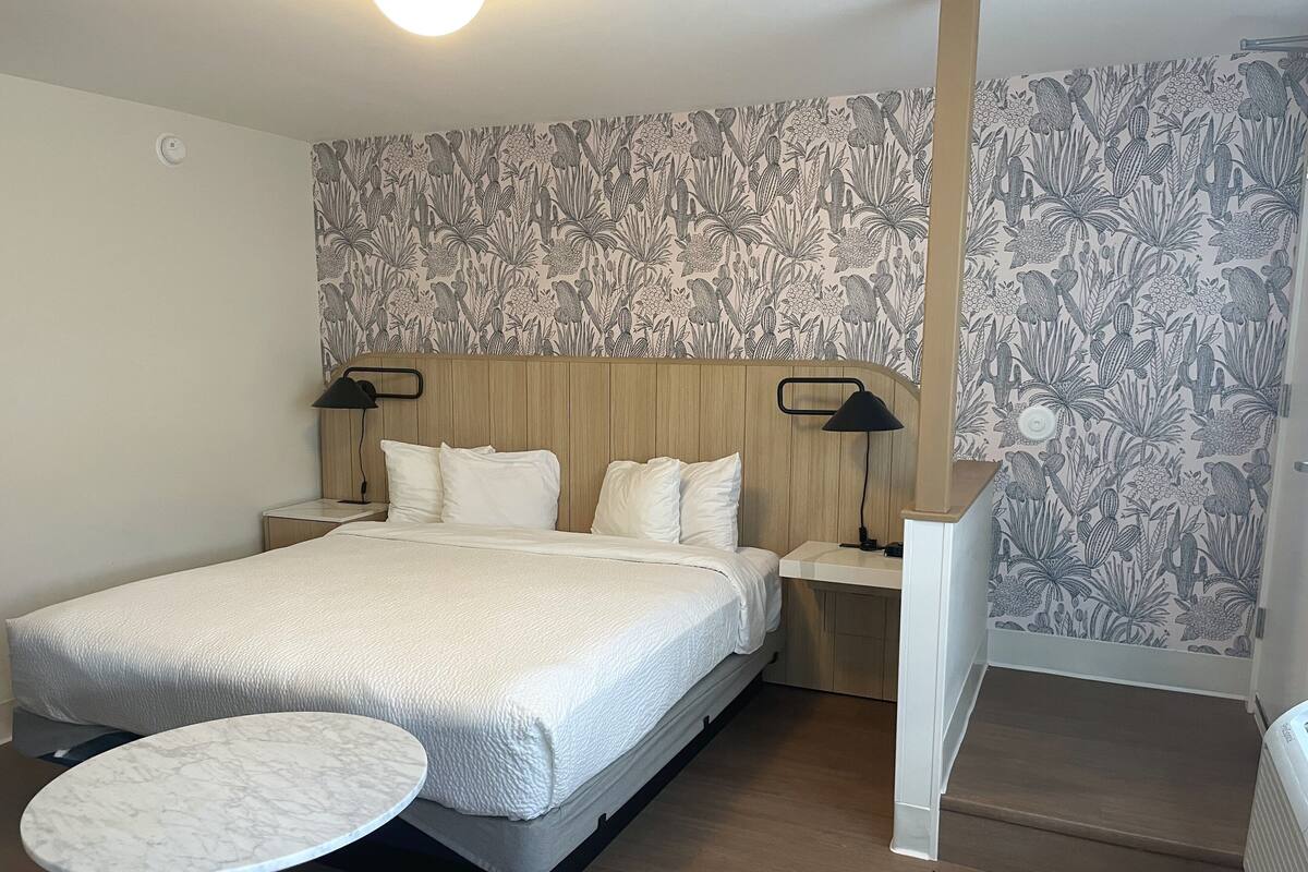 Escritorio, tabla de planchar con plancha y ropa de cama