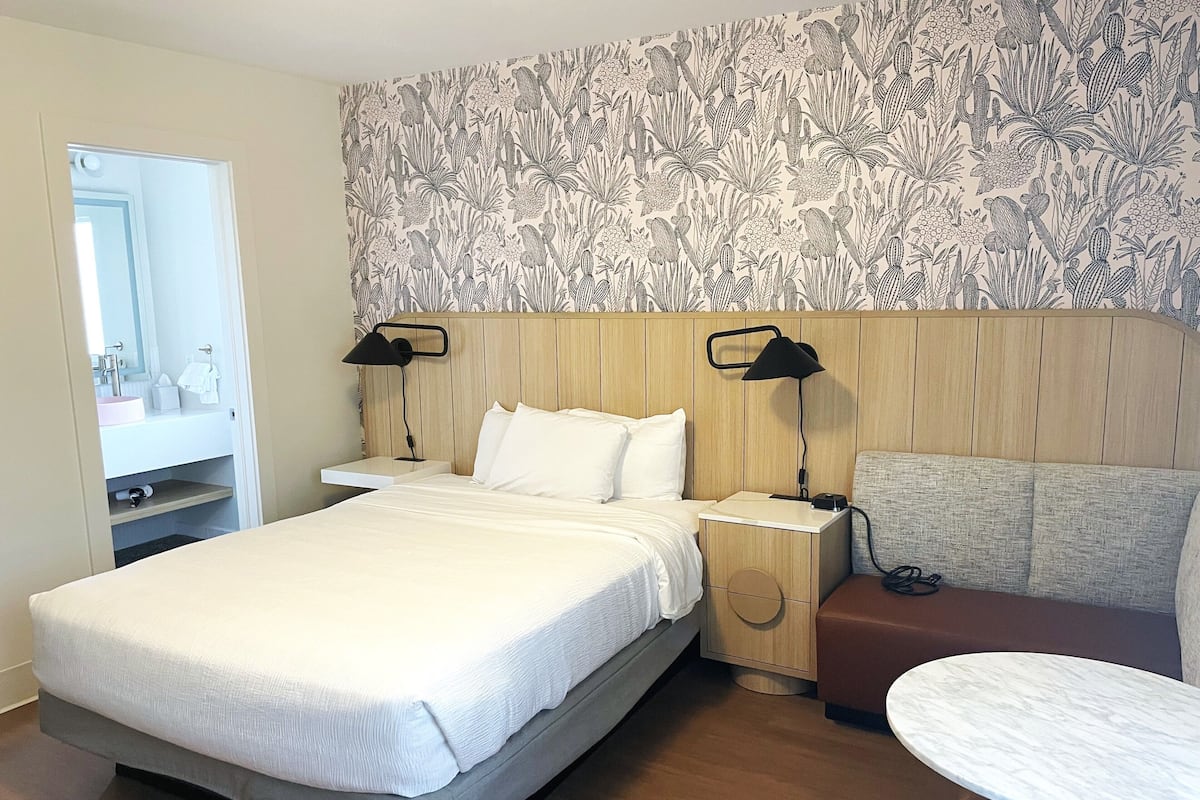 Escritorio, tabla de planchar con plancha y ropa de cama