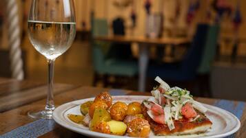 Ein Teller mit Essen und ein Glas Wasser auf einem Holztisch.