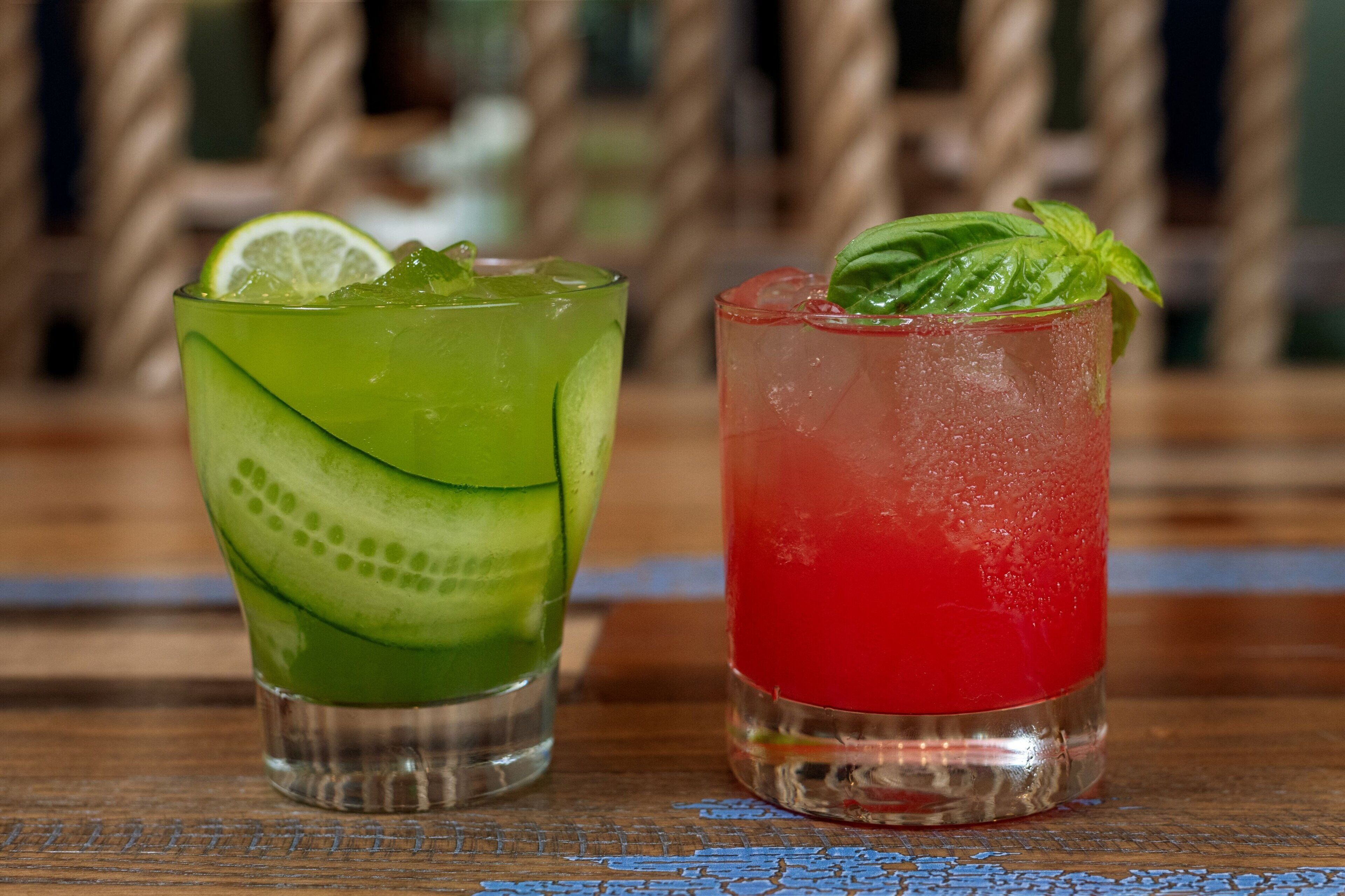 Two glasses of beverages on a wooden surface.