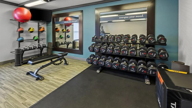 A gym with exercise equipment, a mirror, and motivational wall text. - Hampton Inn Toledo-South/Maumee (Maumee)