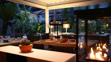 An outdoor dining area with tables, chairs, and a fire feature.