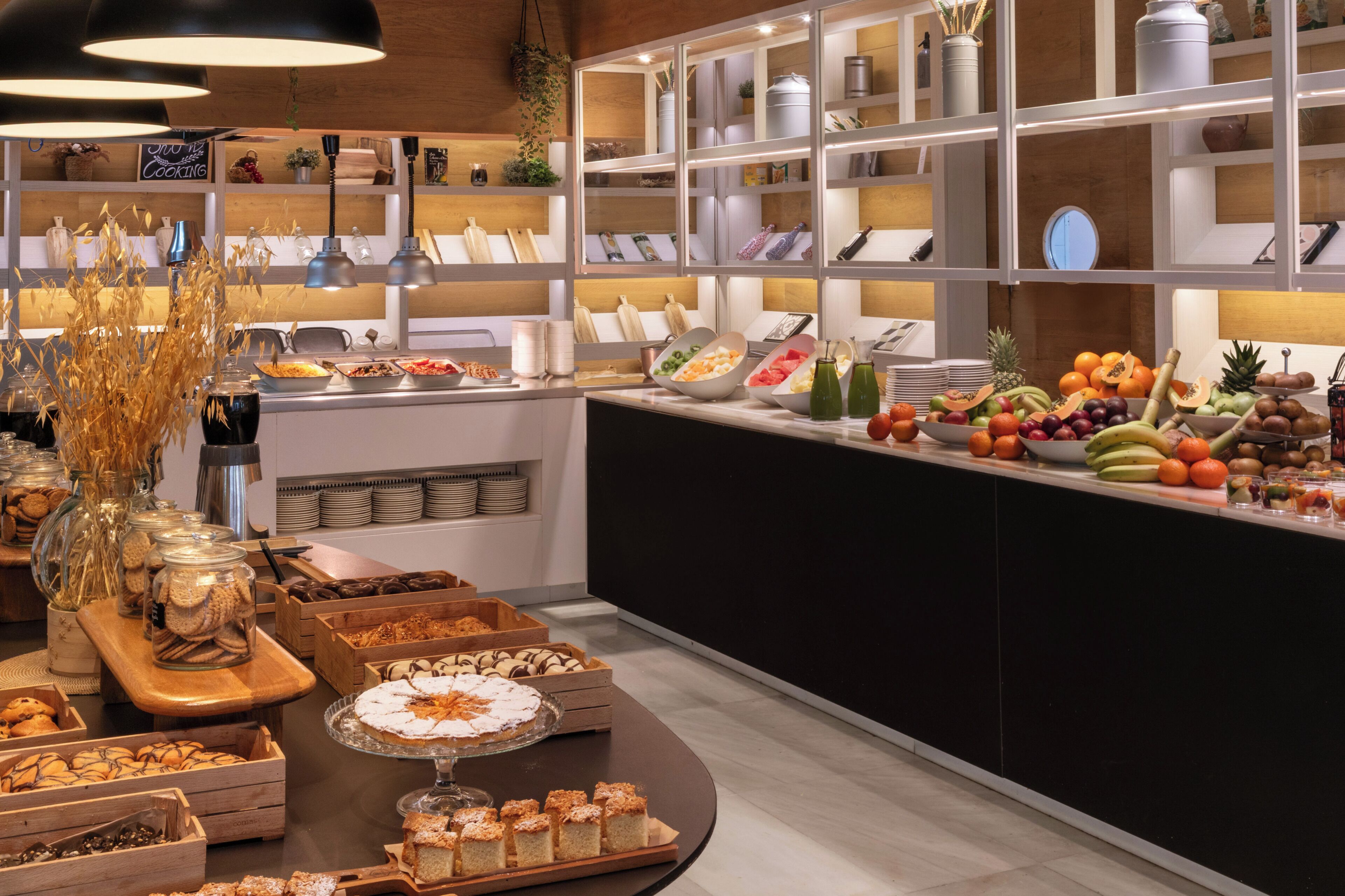 Un bufé con diferentes opciones de comida y una exhibición ordenada de utensilios de cocina.