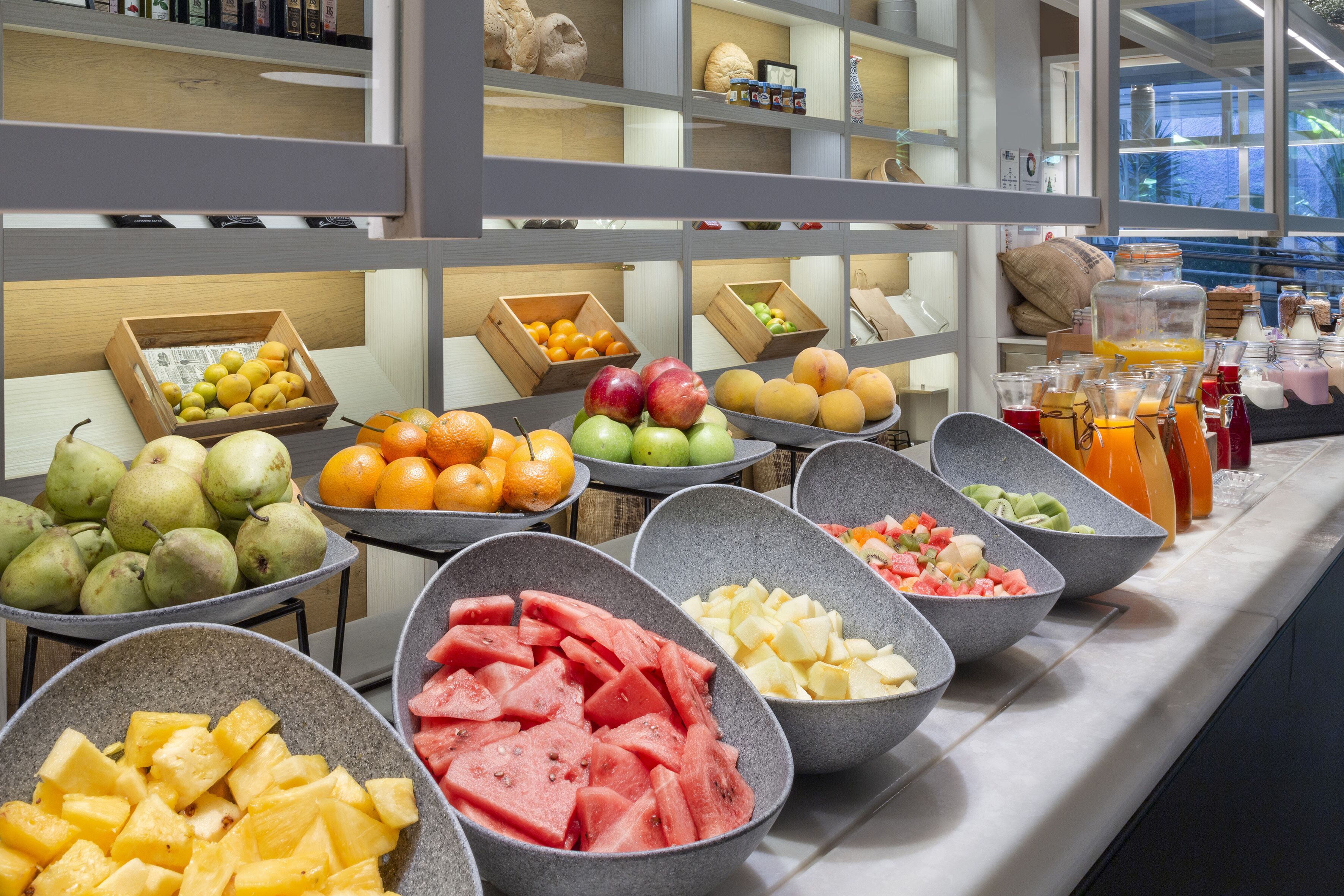 A buffet with various fruits and beverages.