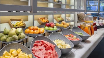 A buffet with various fruits and beverages.