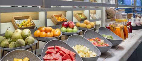 A buffet with various fruits and beverages.