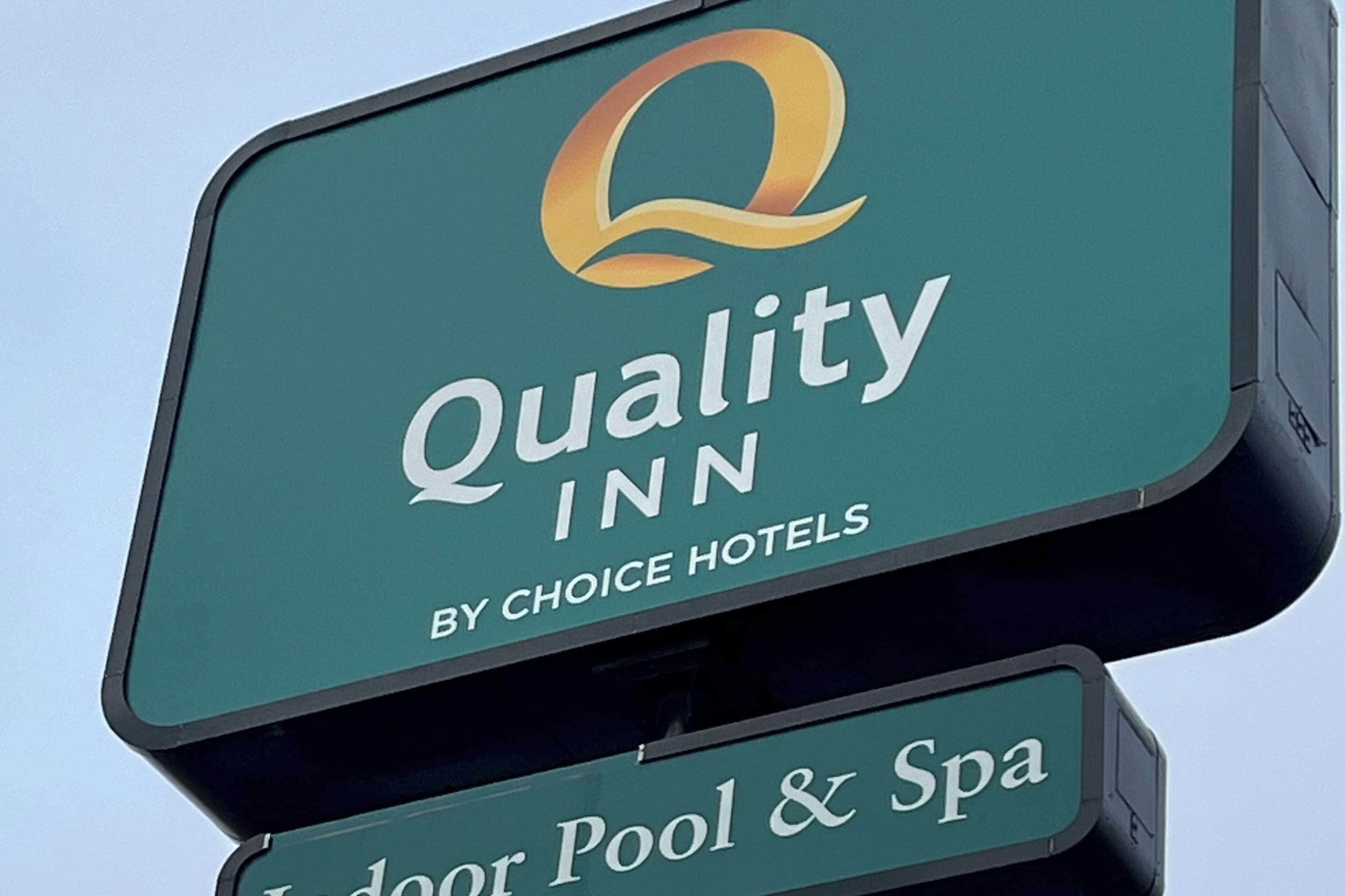 Placa da Quality Inn by Choice Hotels com logotipo e o texto 'Piscina Coberta e Spa'.