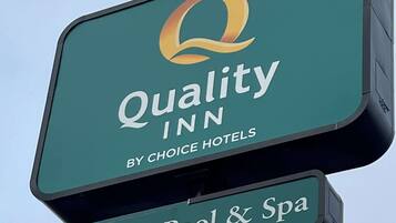 Placa da Quality Inn by Choice Hotels com logotipo e o texto 'Piscina Coberta e Spa'.