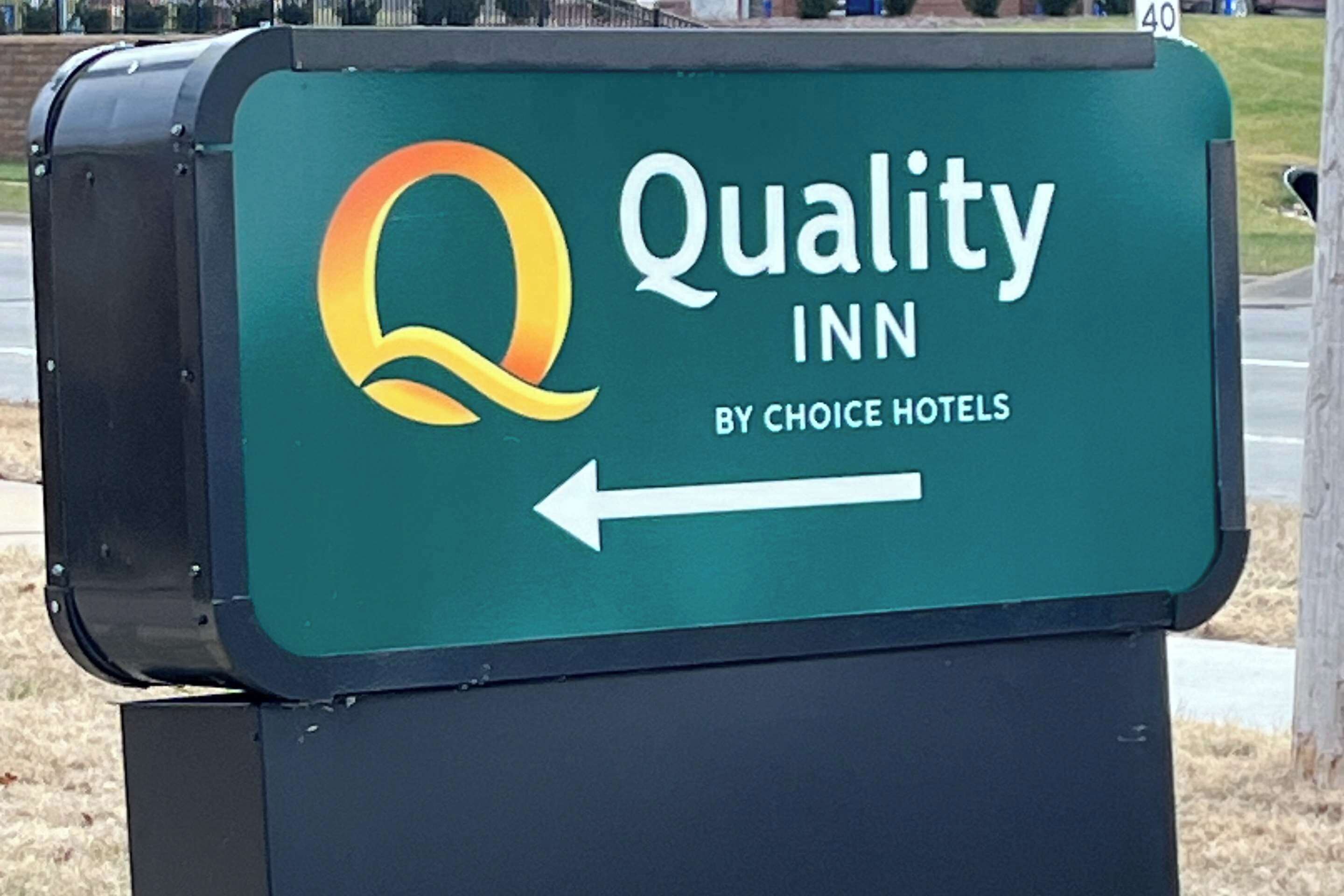 A sign for Quality Inn by Choice Hotels with a directional arrow.