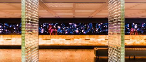 A modern lobby with a glass partition, a reception desk, and a seating area.