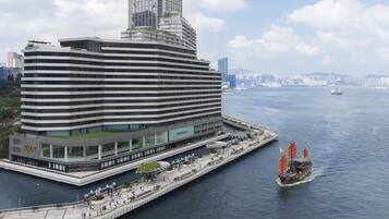 A modern hotel with a waterfront promenade, a glass facade, and a prominent 'Regent' sign.